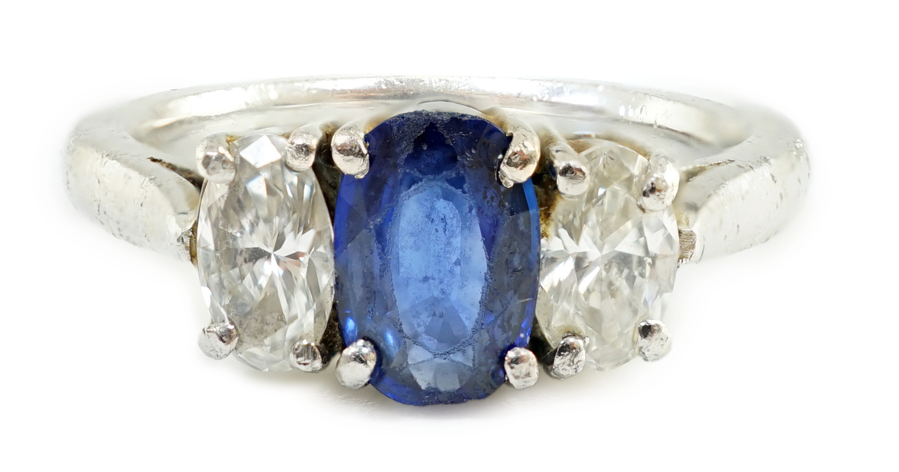 A modern platinum, singe stone oval cut sapphire and two stone oval cut diamond set ring